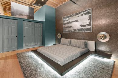 Mid-sized minimalist master medium tone wood floor and brown floor bedroom photo in Milwaukee with green walls