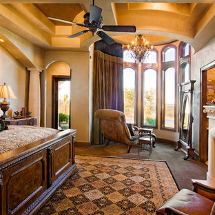 Diseño de dormitorio principal, mediterráneo, extra grande, con paredes beige, suelo de travertino, chimenea tradicional y marco de chimenea de piedra
