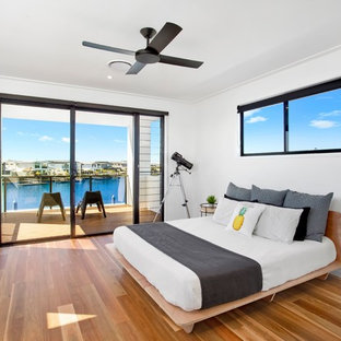 Contemporary master bedroom in Gold Coast - Tweed with white walls, medium hardwood floors and brown floor.