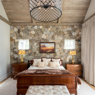 Foto de dormitorio principal, de estilo de casa de campo, grande, con paredes blancas, suelo de madera clara, chimenea tradicional, marco de chimenea de metal y suelo marrón