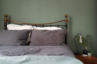 This is an example of a small traditional master bedroom in London with green walls.
