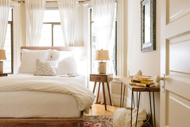Imagen de dormitorio principal contemporáneo pequeño con paredes beige, suelo de madera clara y suelo beige