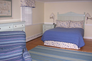 Diseño de habitación de invitados clásica de tamaño medio sin chimenea con paredes beige, suelo de madera en tonos medios y suelo marrón