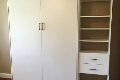 Modelo de habitación de invitados pequeña con paredes beige y suelo de madera en tonos medios