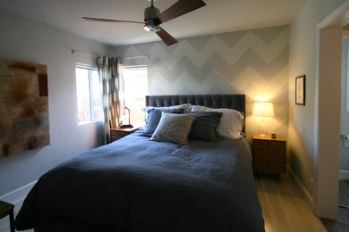 Foto de dormitorio principal moderno pequeño sin chimenea con paredes grises y suelo de madera clara