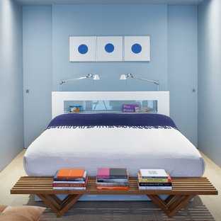 Diseño de dormitorio industrial con paredes azules y suelo de madera clara
