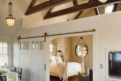 Example of a mid-sized farmhouse medium tone wood floor bedroom design in Boston with white walls