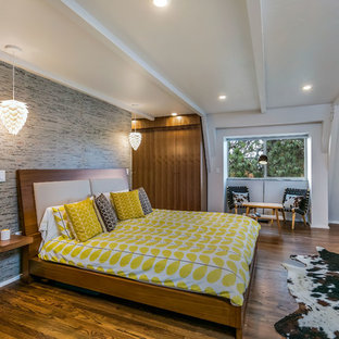 Imagen de dormitorio principal, retro, grande, con paredes blancas, suelo de madera oscura y chimenea de esquina