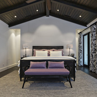 Modelo de habitación de invitados mediterránea, grande, con paredes blancas y suelo de madera oscura