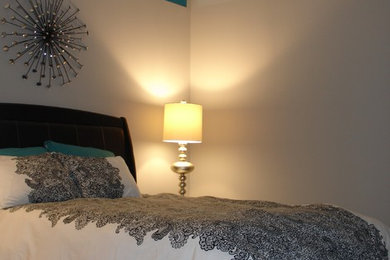 Modelo de dormitorio minimalista sin chimenea con paredes beige y suelo de madera oscura