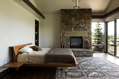 Идея дизайна: большая хозяйская спальня в современном стиле с бежевыми стенами, светлым паркетным полом, стандартным камином и фасадом камина из камня