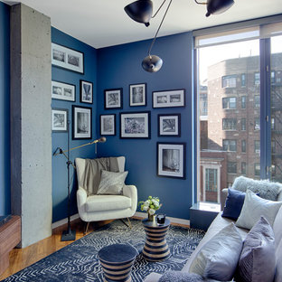 Modelo de dormitorio contemporáneo con paredes azules, suelo de madera en tonos medios y suelo marrón