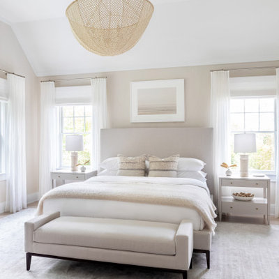 Example of a large classic master light wood floor and brown floor bedroom design in New York with beige walls and no fireplace
