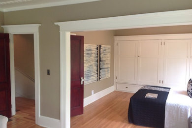 Foto de dormitorio principal de estilo americano de tamaño medio sin chimenea con paredes beige, suelo de madera clara y suelo marrón