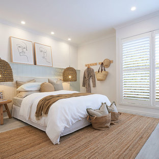 Inspiration for a beach style bedroom in Melbourne with white walls, light hardwood floors and beige floor.