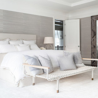 Réalisation d'une très grand chambre parentale tradition avec un mur beige, un sol en bois foncé, une cheminée standard et un manteau de cheminée en pierre.