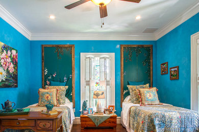 オースティンにある広いエクレクティックスタイルのおしゃれな客用寝室 (青い壁、無垢フローリング、茶色い床) のインテリア