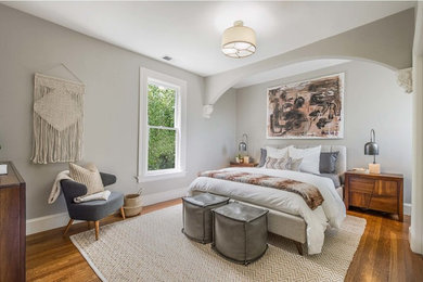 Стильный дизайн: спальня в стиле неоклассика (современная классика) с серыми стенами, паркетным полом среднего тона и коричневым полом - последний тренд