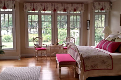 Imagen de dormitorio principal tradicional renovado de tamaño medio sin chimenea con paredes blancas y suelo de madera clara