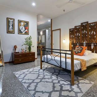 Design ideas for a mid-sized tropical bedroom in Cairns with white walls, concrete floors and grey floor.