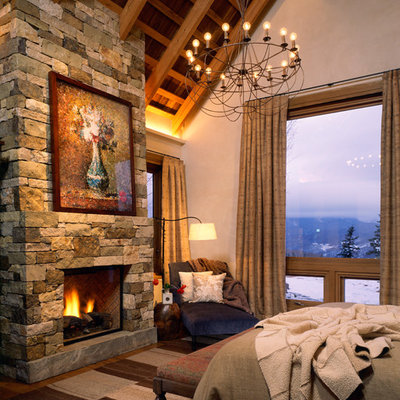 Bedroom - large rustic master bedroom idea in Denver with a standard fireplace, a stone fireplace and white walls