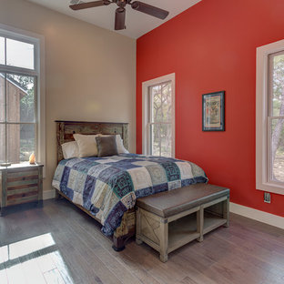 Imagen de habitación de invitados de estilo de casa de campo, de tamaño medio, sin chimenea, con paredes rojas, suelo de madera en tonos medios y suelo marrón