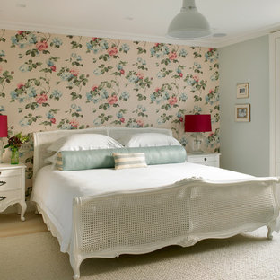 Large traditional master bedroom in London with multi-coloured walls, beige floors and light hardwood flooring.