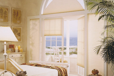 Diseño de dormitorio principal costero de tamaño medio sin chimenea con paredes beige, suelo de madera clara y suelo blanco