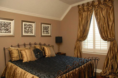 Imagen de dormitorio tradicional de tamaño medio con paredes beige y suelo de madera en tonos medios