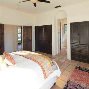 Imagen de dormitorio principal, mediterráneo, de tamaño medio, con paredes blancas, suelo de baldosas de terracota y suelo naranja