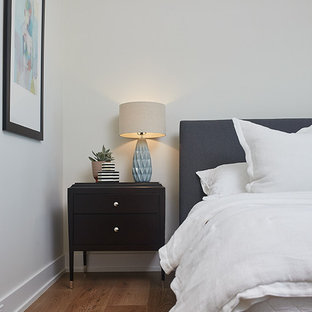 Large trendy guest medium tone wood floor and brown floor bedroom photo in Grand Rapids with beige walls