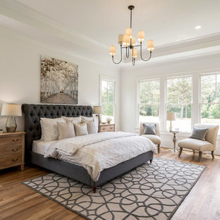 Inspiration for a cottage medium tone wood floor and brown floor bedroom remodel in Atlanta with white walls