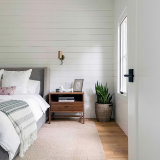 Inspiration for a farmhouse master light wood floor and beige floor bedroom remodel in Austin with white walls