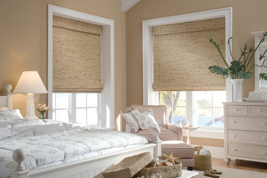 Imagen de habitación de invitados costera grande con paredes beige y suelo de madera clara