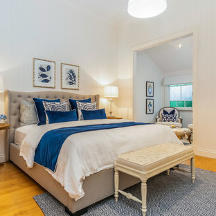 Inspiration for a traditional master bedroom in Brisbane with white walls, medium hardwood floors and brown floor.