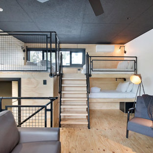 This is an example of a small industrial loft-style bedroom in Sydney with white walls, light hardwood floors and beige floor.