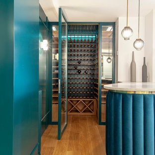 Esempio di una cantina minimal con pavimento in legno massello medio e rastrelliere portabottiglie