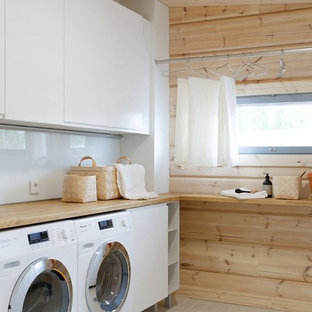 Réalisation d'une buanderie linéaire nordique multi-usage et de taille moyenne avec un placard à porte plane, des portes de placard blanches, un plan de travail en bois, un mur beige, un sol en carrelage de céramique, des machines côte à côte et un plan de travail beige.