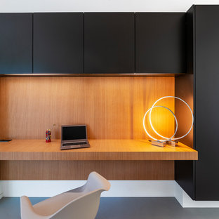 Cette photo montre un bureau tendance en bois avec un bureau intégré, béton au sol et un sol gris.