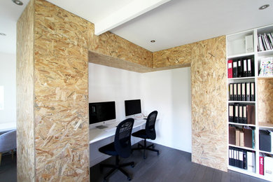 Diseño de despacho actual pequeño sin chimenea con paredes blancas, suelo de madera oscura y escritorio independiente
