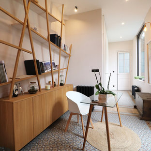 Modern inredning av ett mellanstort hemmabibliotek, med rosa väggar, klinkergolv i terrakotta, ett fristående skrivbord och blått golv