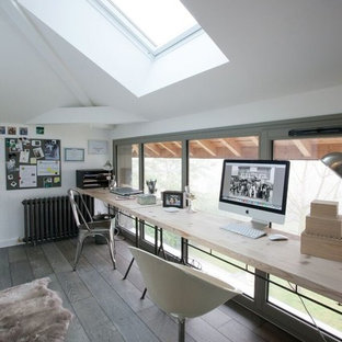 Aménagement d'un bureau industriel de taille moyenne avec un mur blanc, un sol en bois clair, aucune cheminée, un bureau indépendant et un sol marron.