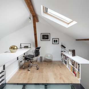 Cette photo montre un bureau tendance de taille moyenne avec un mur blanc, un sol en bois clair, un bureau intégré et aucune cheminée.