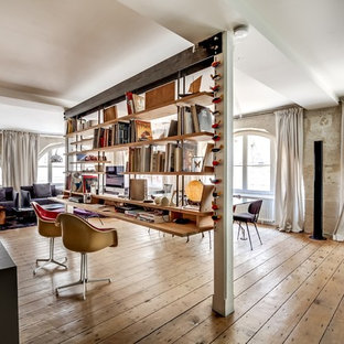 Cette image montre un grand bureau urbain avec un bureau intégré et un sol en bois brun.