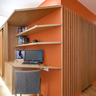 Idéer för små funkis hemmabibliotek, med orange väggar, ljust trägolv och ett inbyggt skrivbord