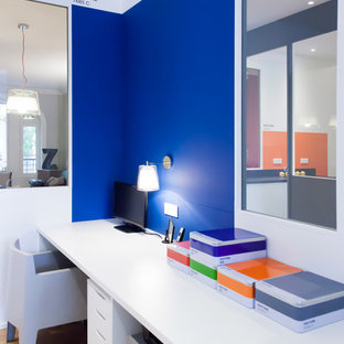 Idée de décoration pour un bureau design de taille moyenne avec un mur bleu, un sol en bois brun et un bureau intégré.