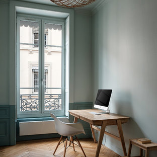 Cette image montre un bureau design avec un mur vert, un sol en bois brun, un bureau indépendant et un sol marron.