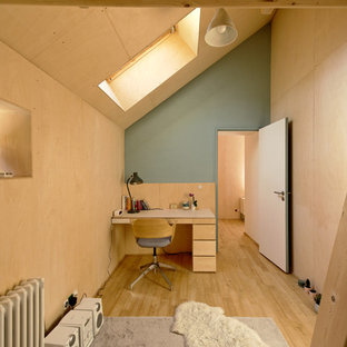 Réalisation d'un bureau design avec un mur vert, un sol en bois brun, un bureau intégré et un sol marron.