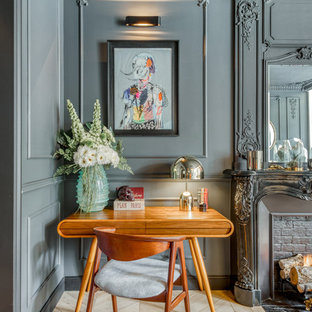 Réalisation d'un bureau bohème avec un mur gris, un sol en bois clair, une cheminée standard, un manteau de cheminée en brique, un bureau indépendant et un sol beige.