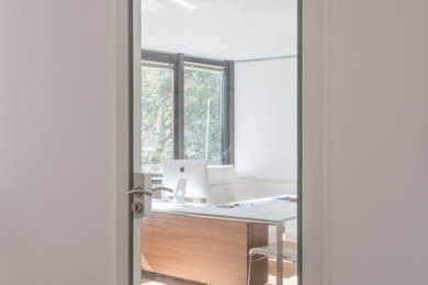 Idée de décoration pour un grand bureau design avec un mur blanc, parquet clair, aucune cheminée et un sol beige.